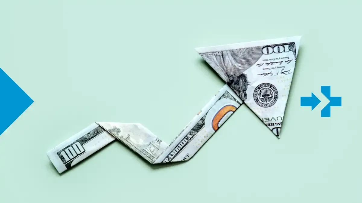 Upward arrow made of folded dollar bills representing rising costs and inflation.