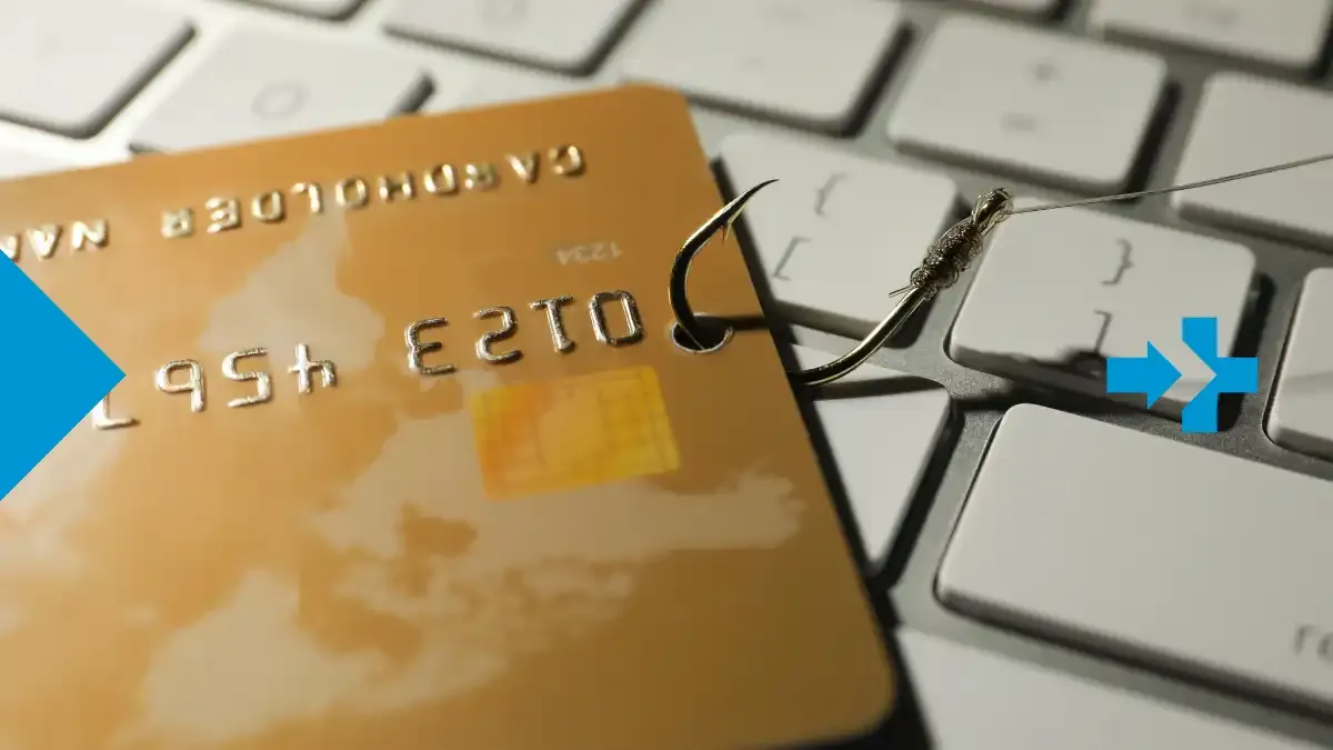 Ein Phishing-Haken, der eine Kreditkarte auf einer Tastatur festhält, als Symbol für Online-Betrug und Scam-Risiken.