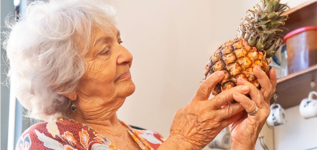 Abuela cubana sonriendo mientras recibe una tarjeta regalo de Mandao a través de Sendvalu, fortaleciendo la conexión familiar a través de la distancia